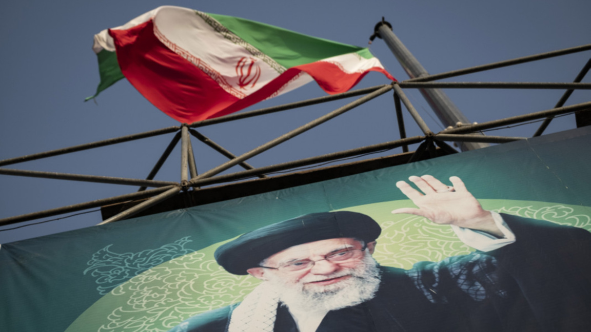 Флагът на Иран се развява над лика на върховния лидер аятолах Али Хаменей в Техеран.