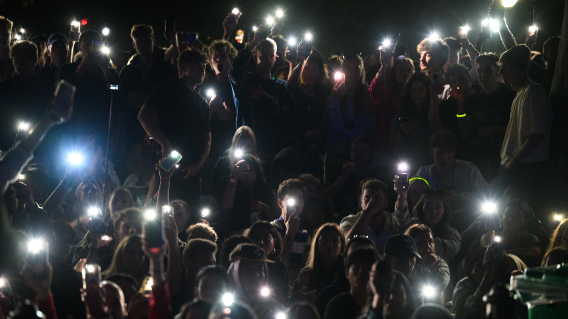 Зрители в Сидни осветяват с мобилните си телефони по време на отдаване на почит към жертвите на терористичната атака в Бонди